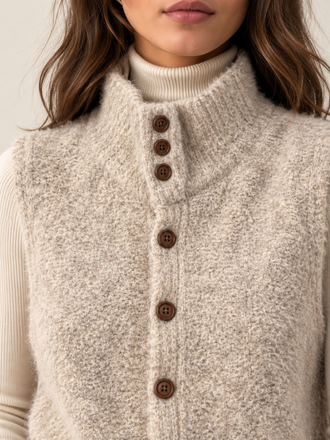 Close-up of the stand collar with button tab, brown buttons and soft boucle knit
