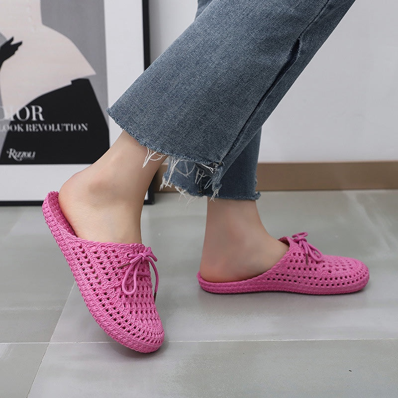 Women's dark pink woven mules with open back, lace-up bow and flat sole, worn