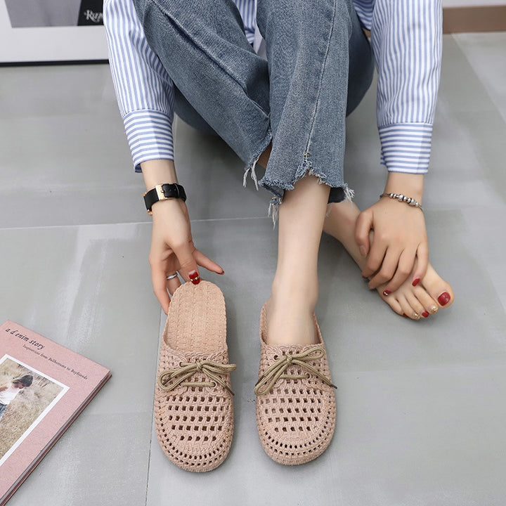 Women's khaki woven mules with open back, lace-up bow and flat sole, worn
